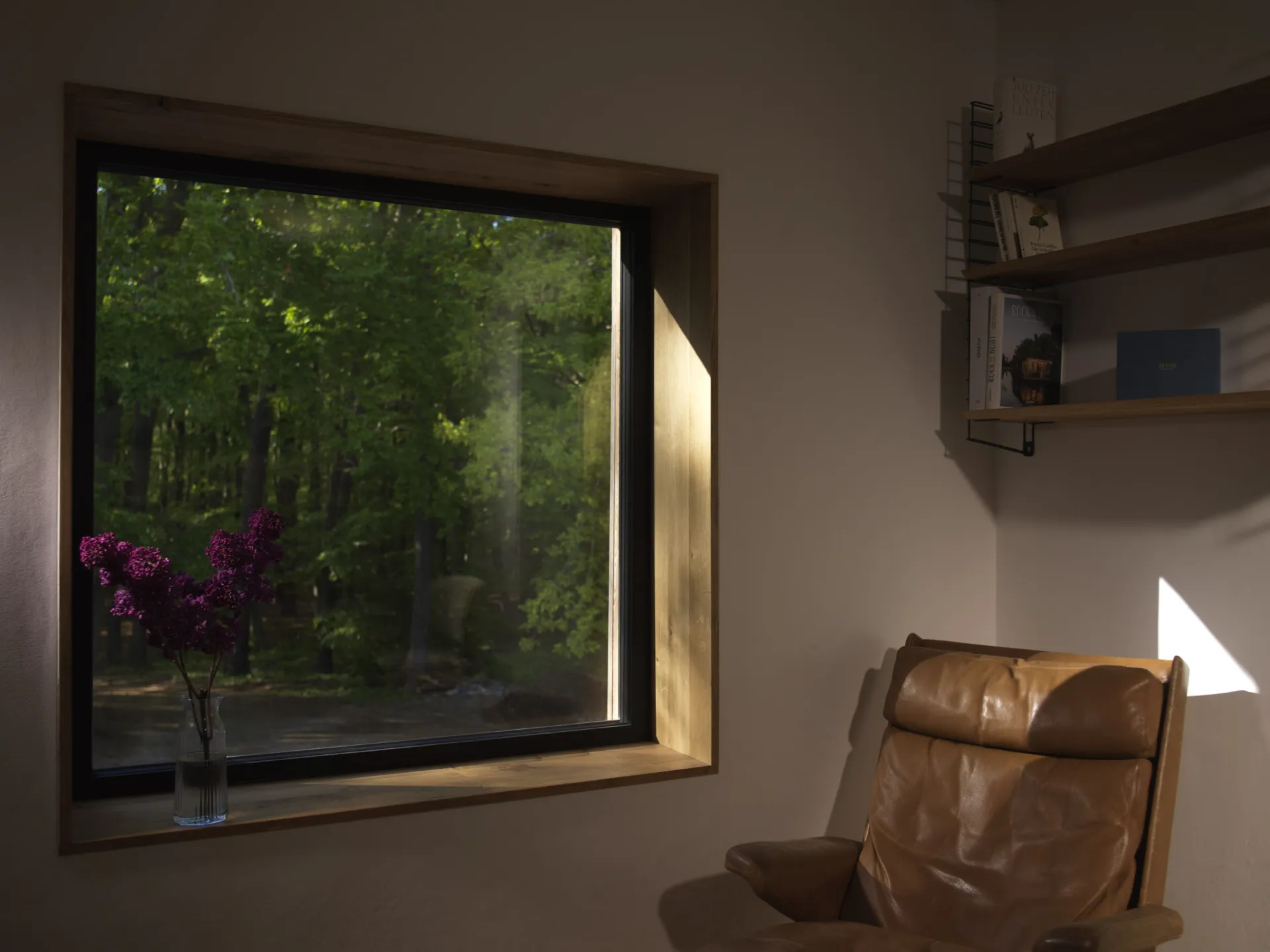 Lesesessel am Fenster zum Wald